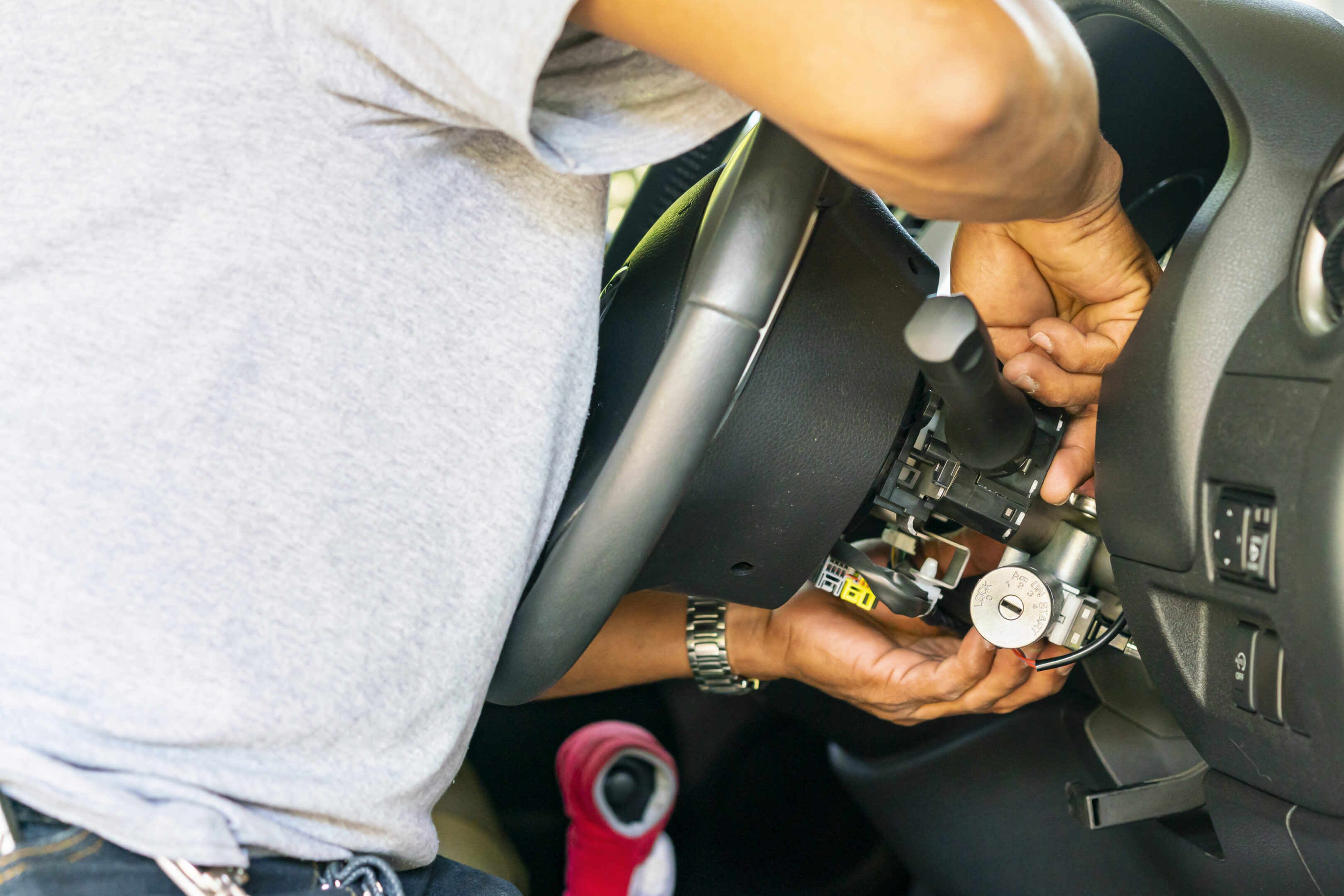 close up hand of technician during repair key or switch engine start of sedan car close up hand of technician during repair key or switch engine start of sedan car